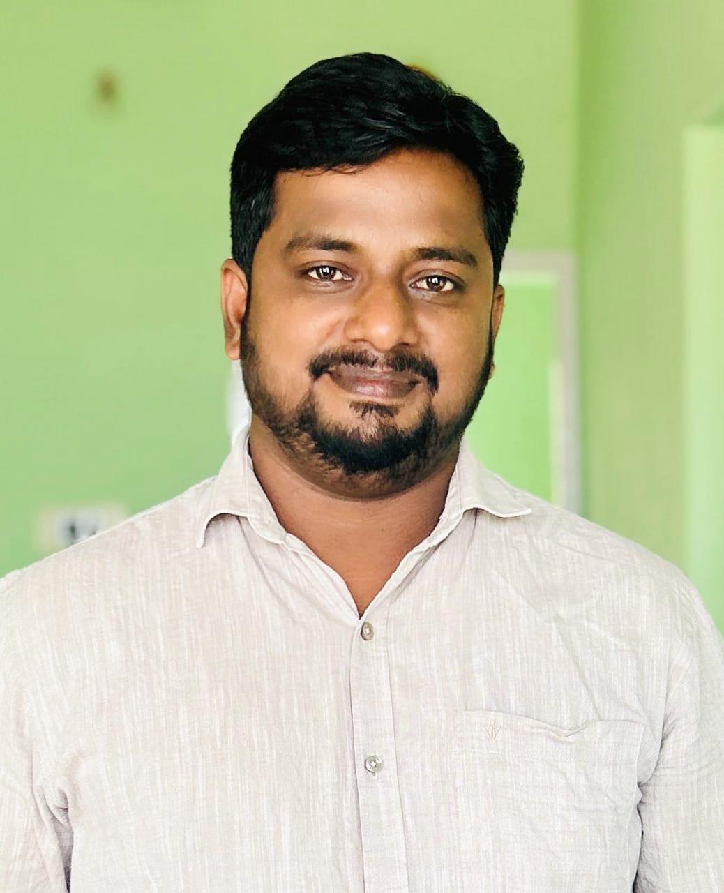 Mr S MohanKumar smiling warmly in a corporate office setting conveying approachable leadership